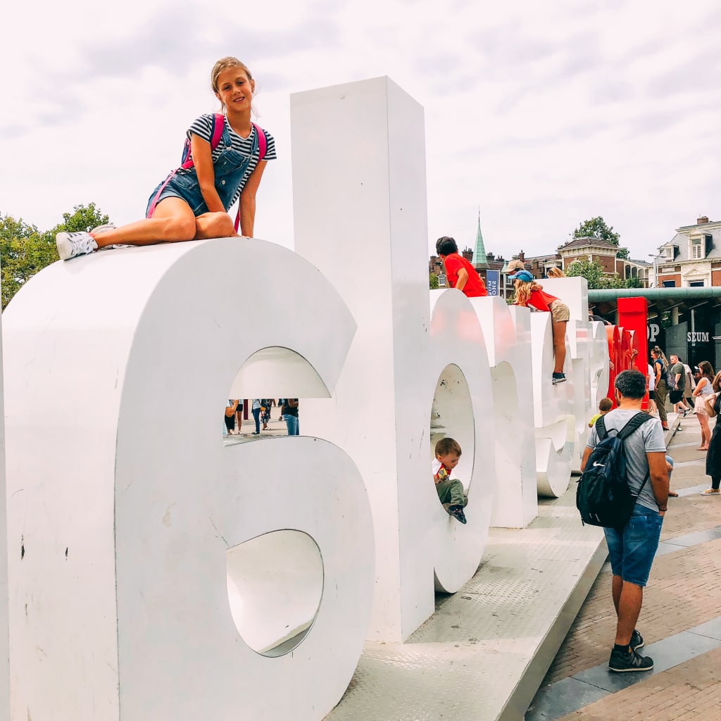 Turisti vicino a una grande scritta "LOVE" ad Amsterdam